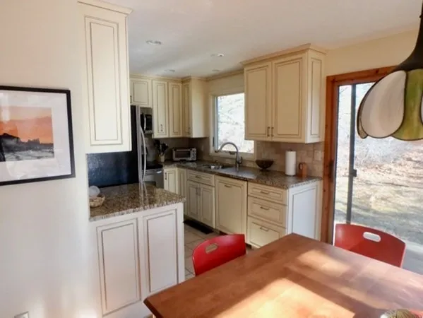 a kitchen with stainless steel appliances granite countertop a sink stove refrigerator and cabinets