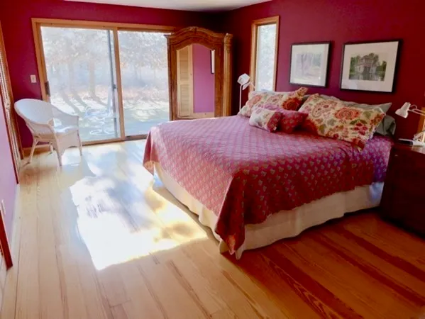 a bedroom with a bed and wooden floor