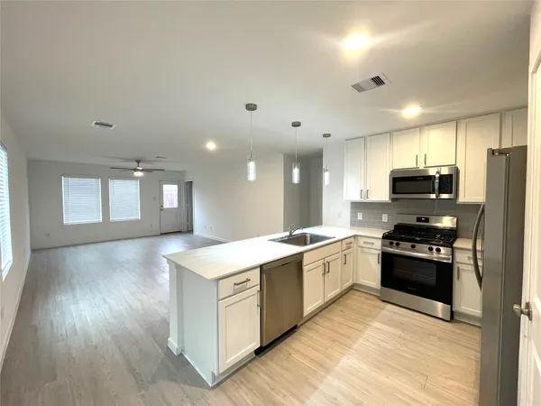 a kitchen with a stove a sink and a refrigerator