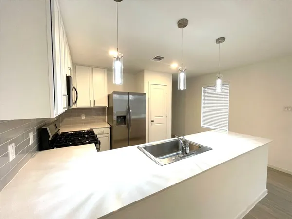 a kitchen with stainless steel appliances kitchen island a refrigerator sink and stove