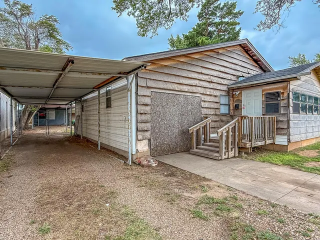 a view of a house with a yard and car parked