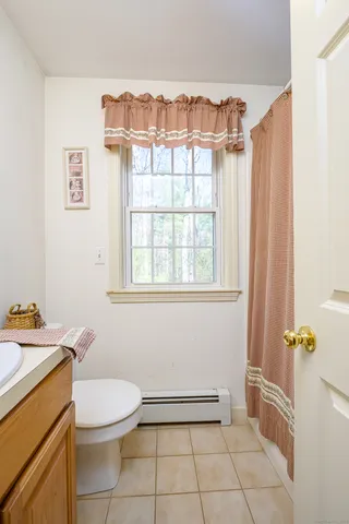 a bathroom with a granite countertop sink a toilet and a shower