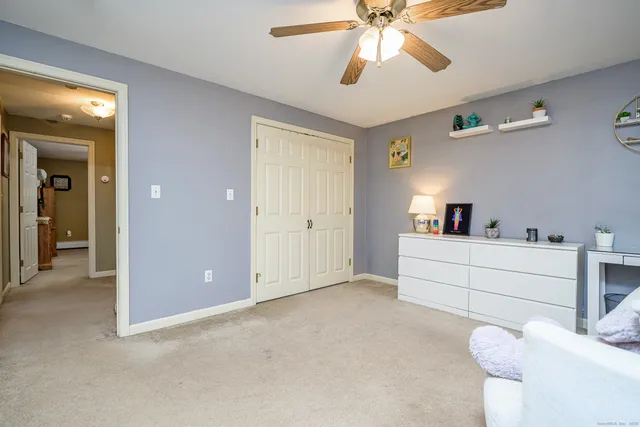 a view of a bedroom with a bed and a ceiling fan