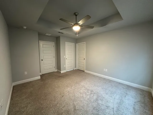 an empty room with closet and a ceiling fan