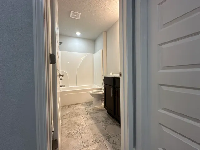 a bathroom with a granite countertop sink toilet and shower