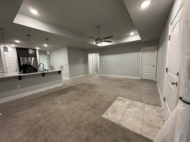 a view of a hallway with a dining table chairs and couches