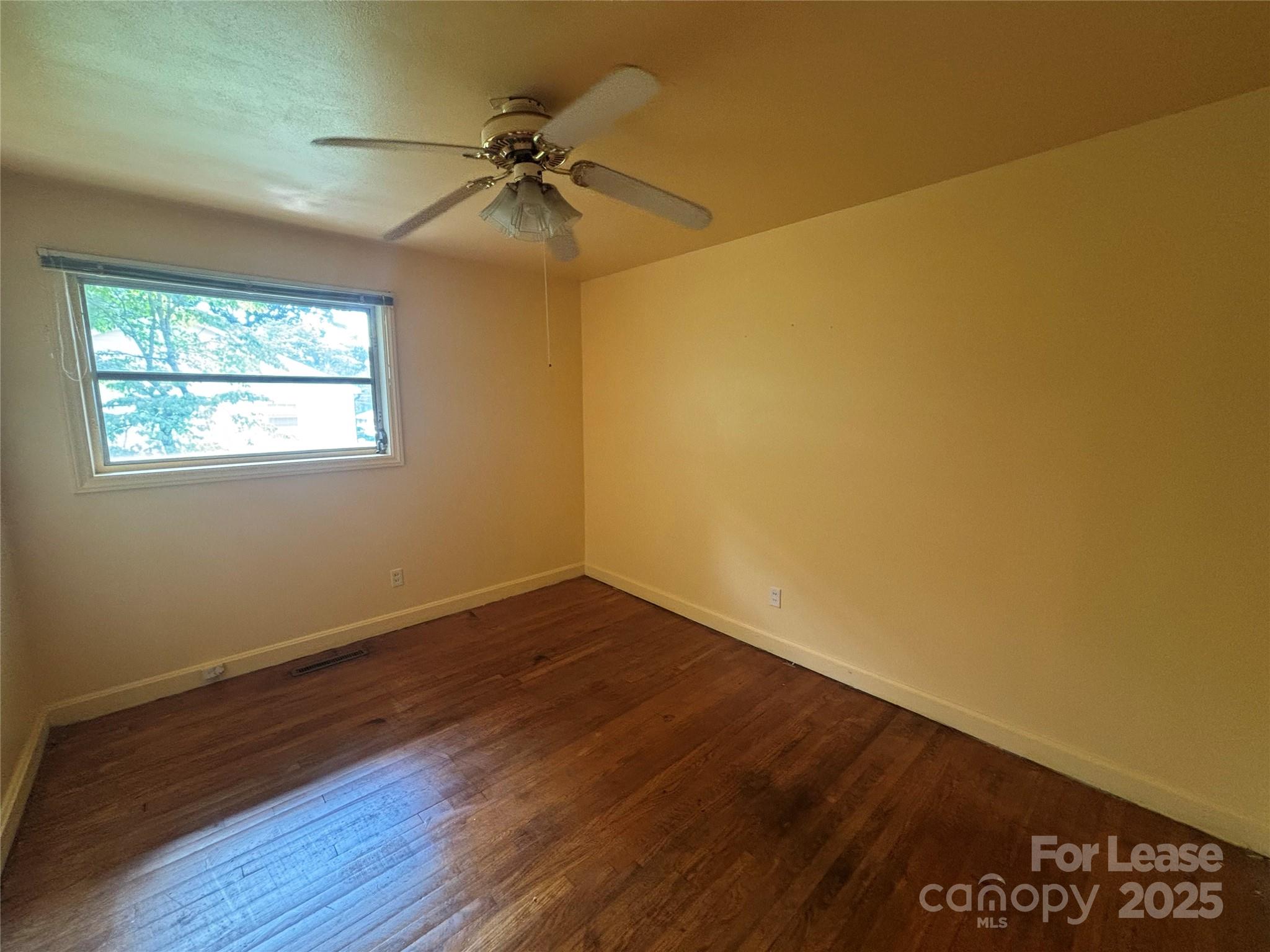 724 Oakdale Drive Statesville, NC 28677 - Photo 11 of 19 a view of an empty room with a window and wooden floor