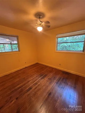 a view of a room with wooden floor and a ceiling fan