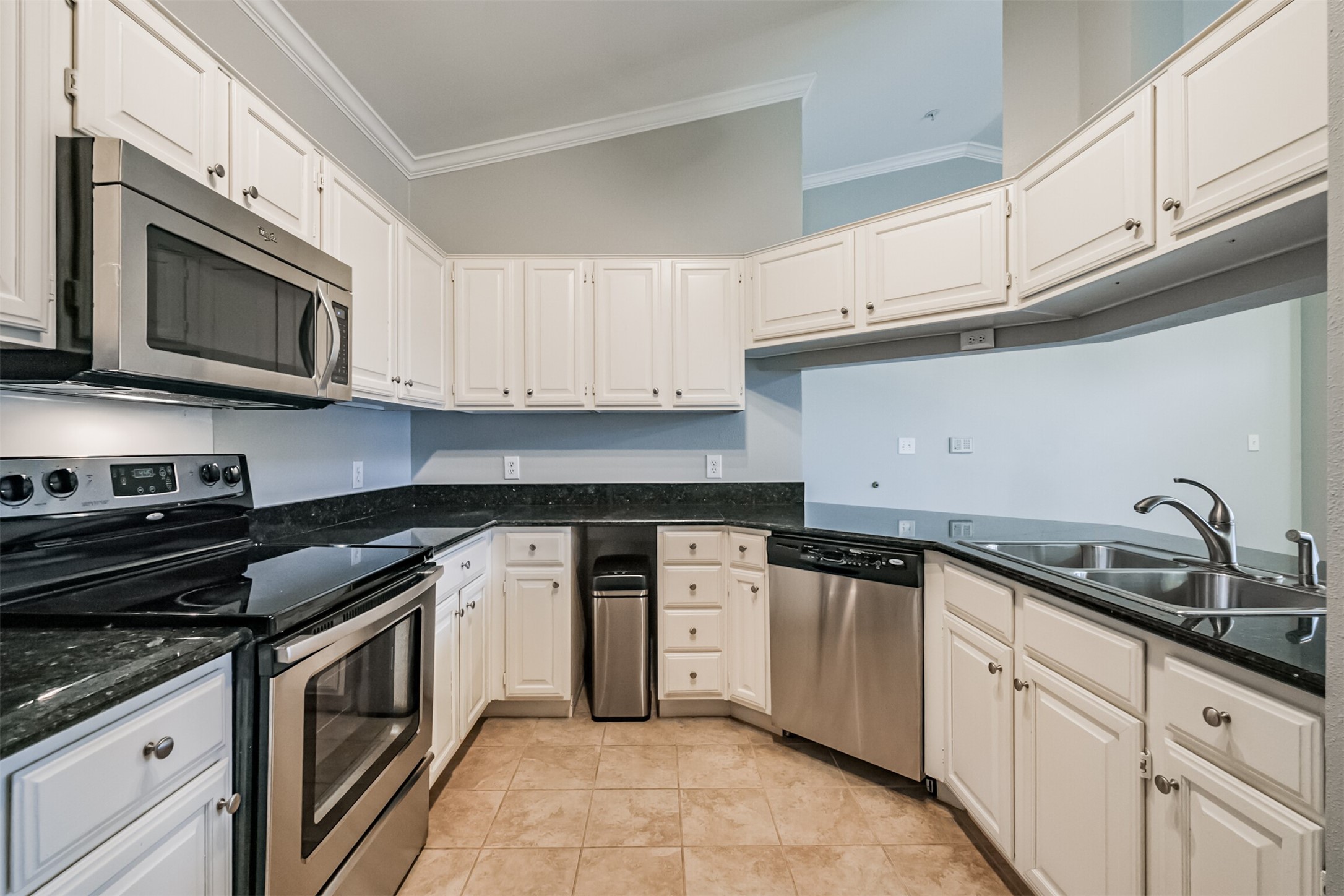 2111 Welch Street, Unit B304 Houston, TX 77019 - Photo 10 of 37 a kitchen with granite countertop white cabinets and stainless steel appliances