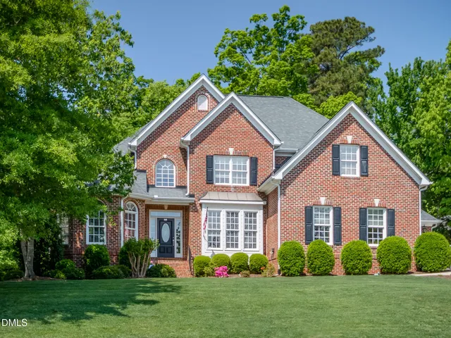 a front view of a house with a garden and plants