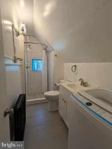 a bathroom with a granite countertop sink a toilet and shower