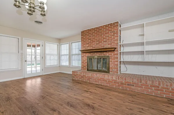 a view of an empty room with a window and fireplace