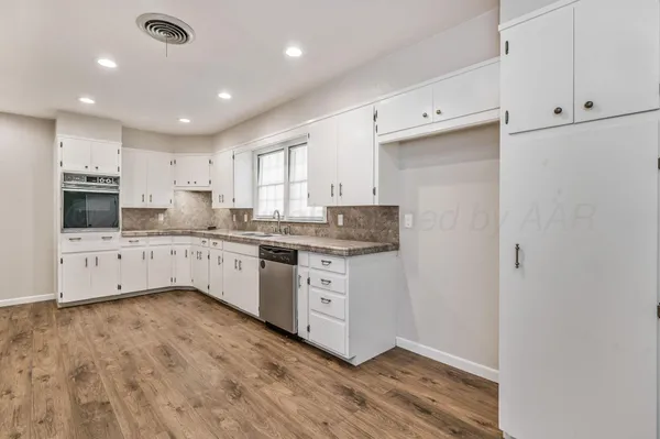 a kitchen with granite countertop white cabinets and white appliances