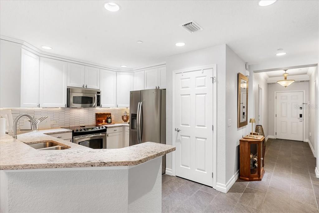 7658 Whisper Way, Unit 402 Reunion, FL 34747 - Photo 13 of 31 a kitchen with stainless steel appliances granite countertop a refrigerator stove and sink