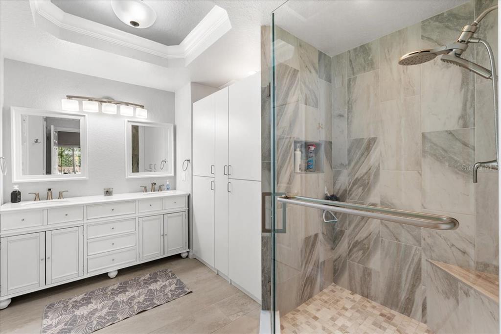 7658 Whisper Way, Unit 402 Reunion, FL 34747 - Photo 15 of 31 a bathroom with a double vanity sink and mirror