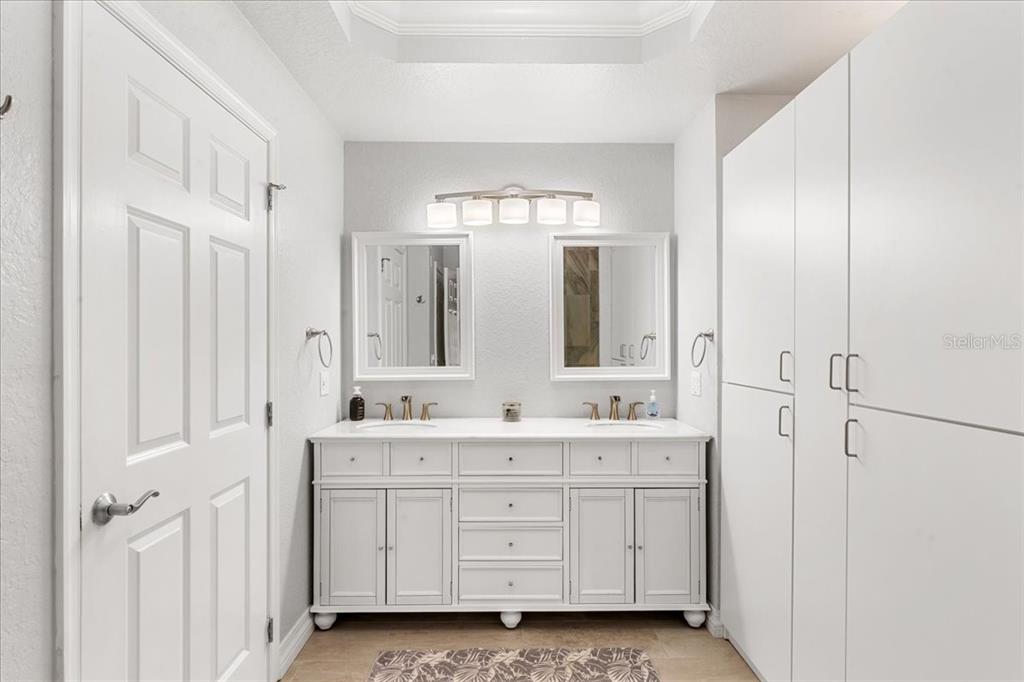 7658 Whisper Way, Unit 402 Reunion, FL 34747 - Photo 16 of 31 a bathroom with a double vanity sink a mirror a window and a bathtub
