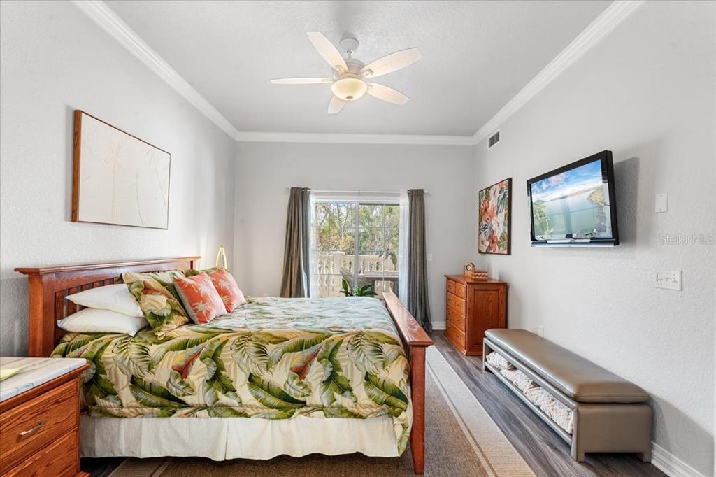 7658 Whisper Way, Unit 402 Reunion, FL 34747 - Photo 17 of 31 a bedroom with a bed and a flat screen tv
