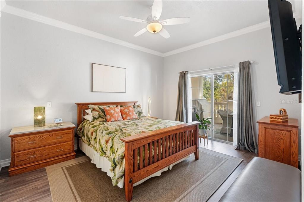 7658 Whisper Way, Unit 402 Reunion, FL 34747 - Photo 18 of 31 a bedroom with a bed and a flat tv screen on the dresser