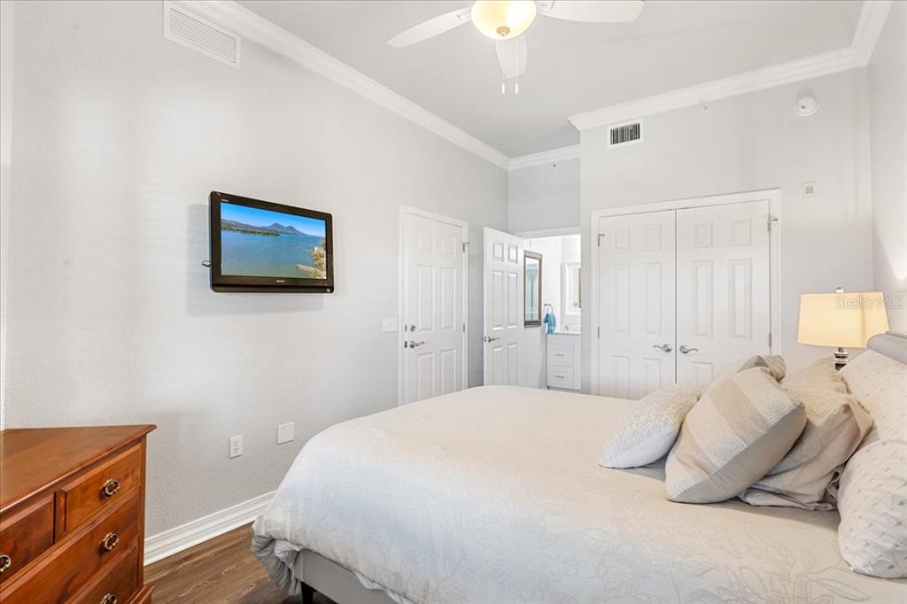7658 Whisper Way, Unit 402 Reunion, FL 34747 - Photo 24 of 31 a bedroom with a bed and a lamp on dresser
