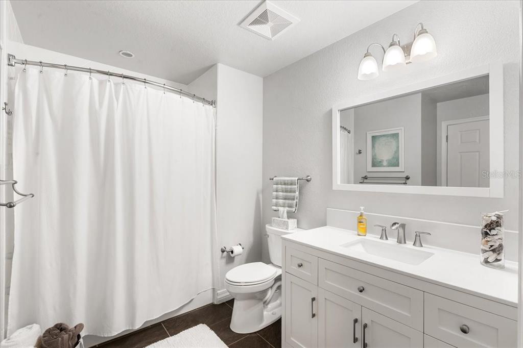 7658 Whisper Way, Unit 402 Reunion, FL 34747 - Photo 25 of 31 a bathroom with a double vanity sink toilet and a mirror