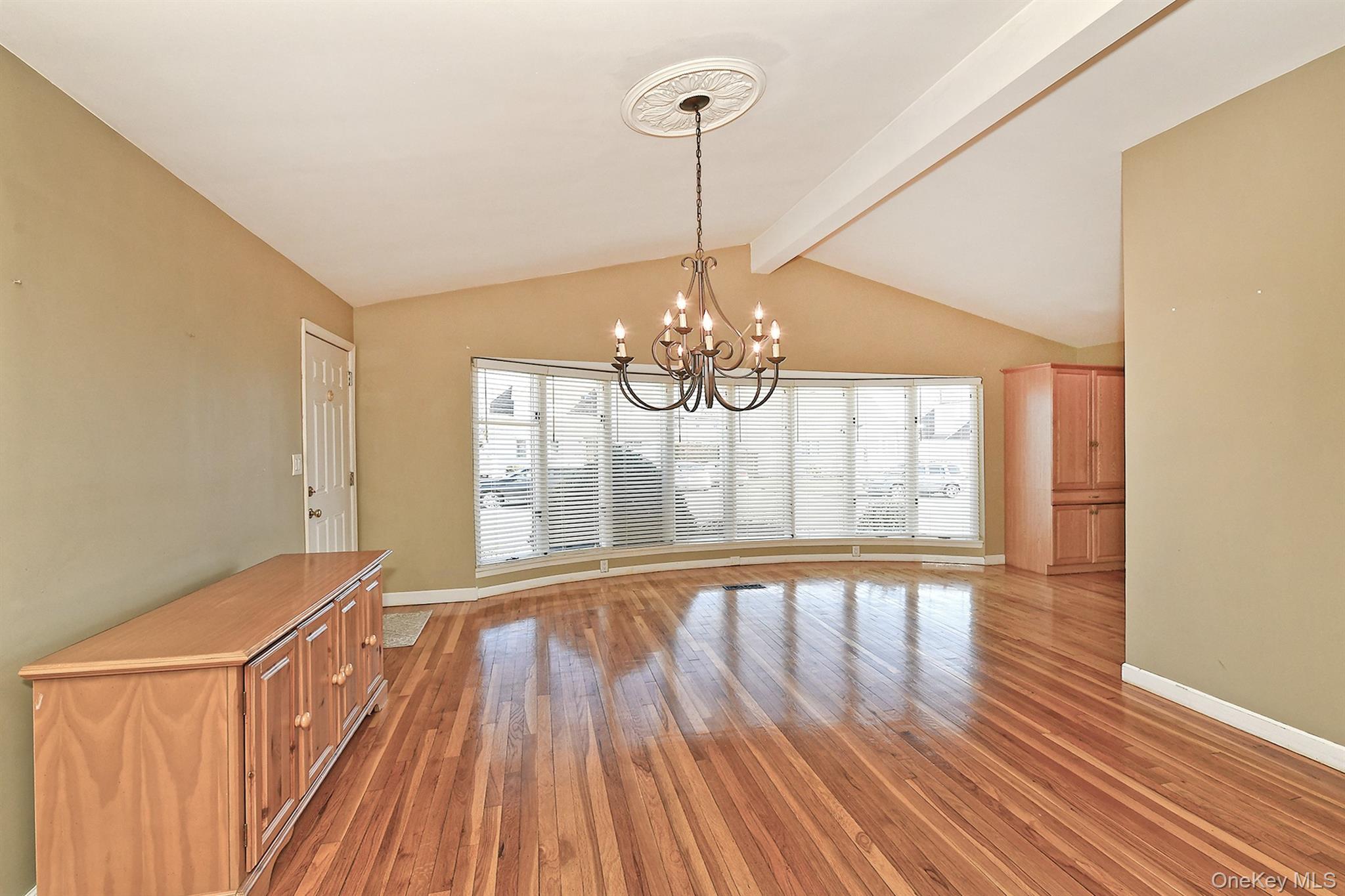 122 Miller Road Hicksville, NY 11801 - Photo 13 of 27 Bay window in dining room wood finished floors and a chandelier