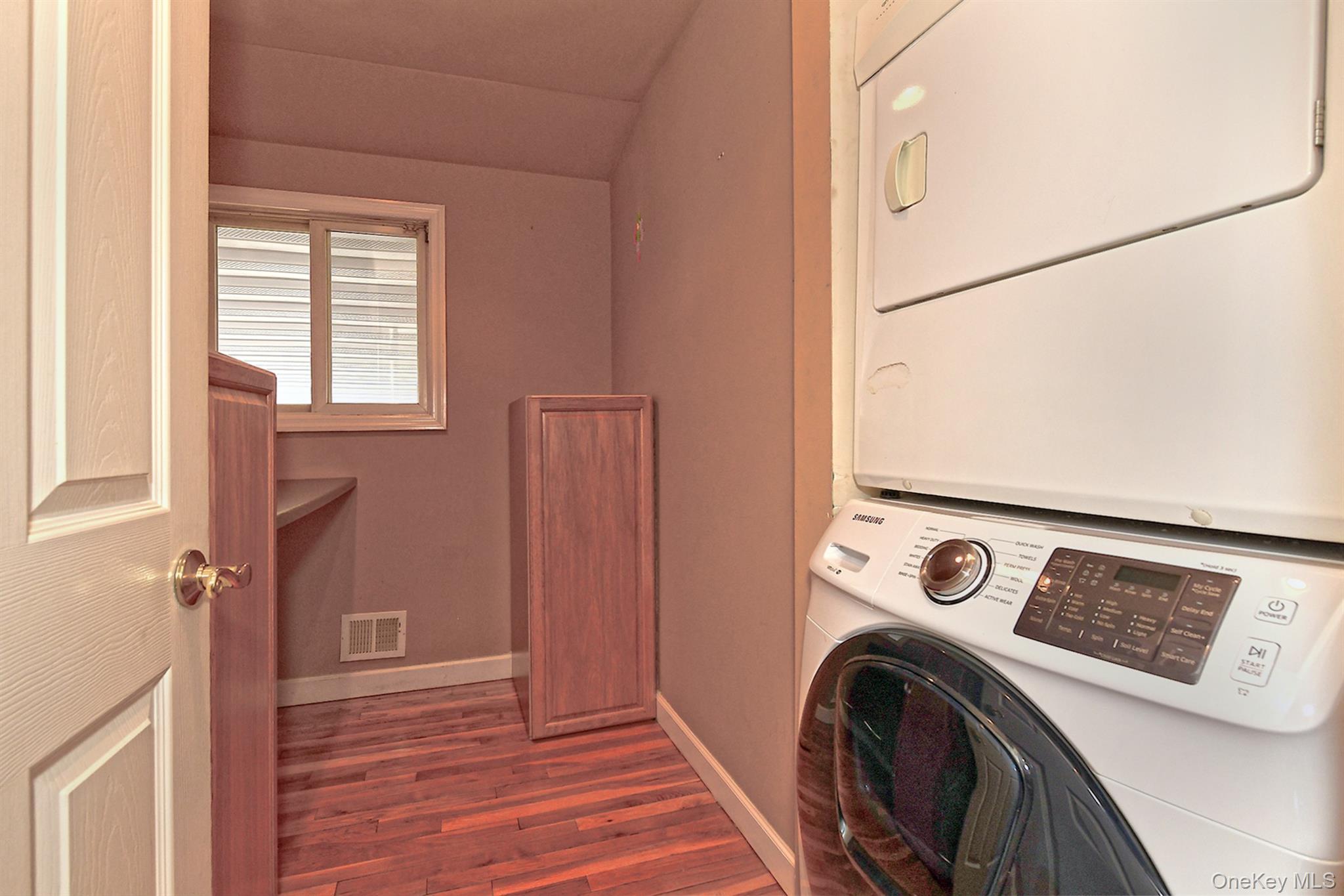 122 Miller Road Hicksville, NY 11801 - Photo 15 of 27 Laundry room featuring dark wood finished floors and stacked washer and clothes dryer