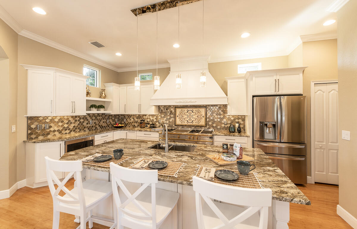 2 Go Lane Key West, FL 33040 - Photo 9 of 42 a kitchen with a refrigerator a stove and a dining table with wooden floor
