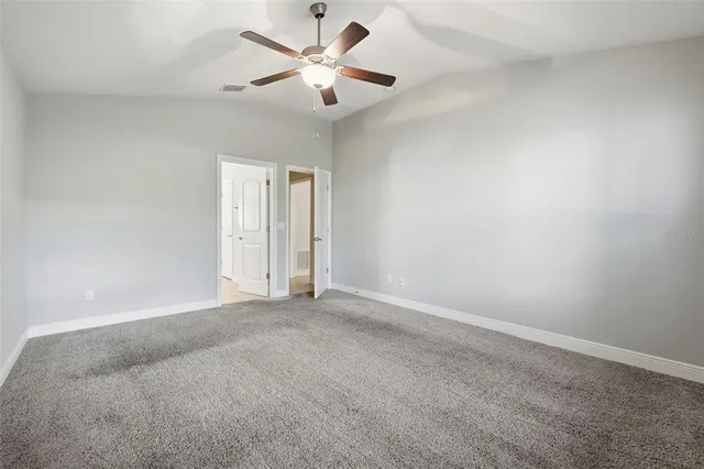 an empty room with a window and a ceiling fan