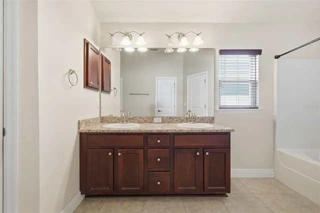 a bathroom with a granite countertop sink a mirror and a vanity