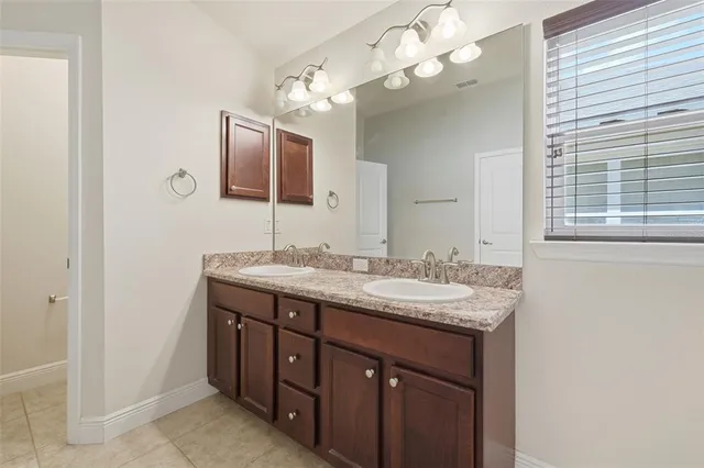 a bathroom with a granite countertop sink a large mirror and a light fixture