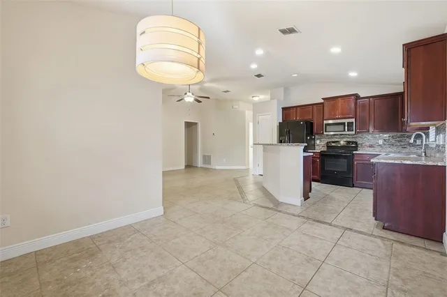 a kitchen with stainless steel appliances granite countertop a refrigerator and a sink
