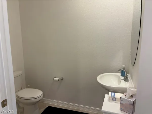 a bathroom with a sink a toilet and mirror