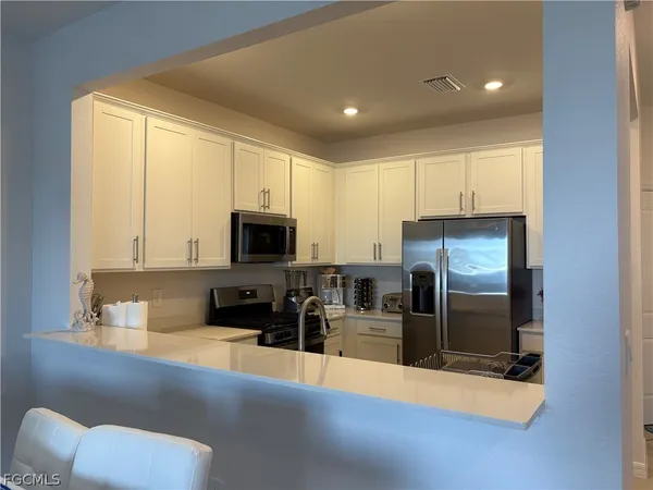 a kitchen with stainless steel appliances a refrigerator sink and microwave