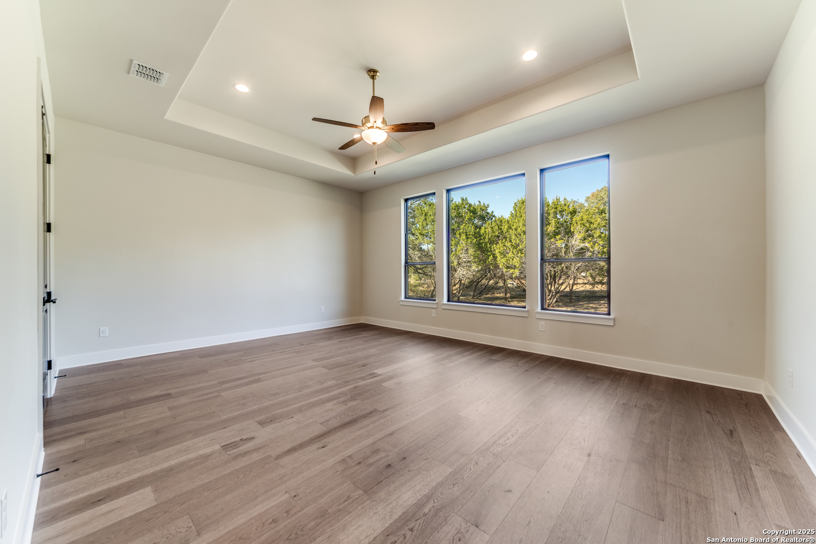193 Ranch Heights Boerne, TX 78015 - Photo 15 of 29 an empty room with wooden floor fan and windows