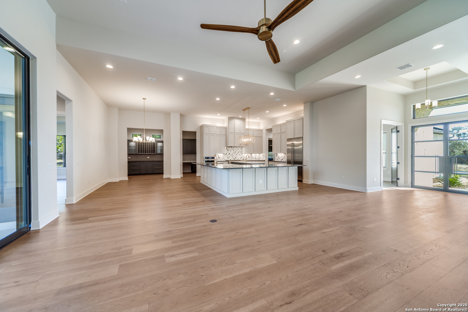 193 Ranch Heights Boerne, TX 78015 - Photo 3 of 29 a view of an empty room and kitchen with stainless steel appliances wooden floor