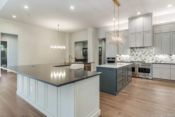 a kitchen with kitchen island granite countertop a sink cabinets and stainless steel appliances