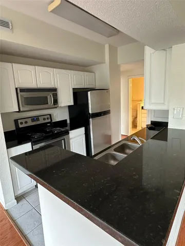a kitchen with a sink and a stove top oven