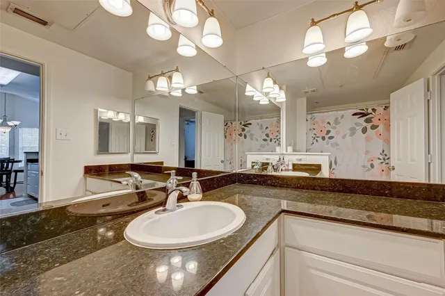 a bathroom with a sink a large mirror and a toilet