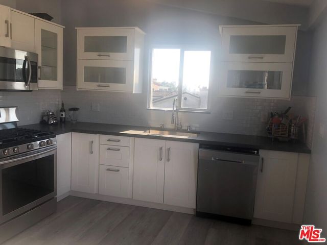 a kitchen with stainless steel appliances granite countertop a refrigerator and a stove