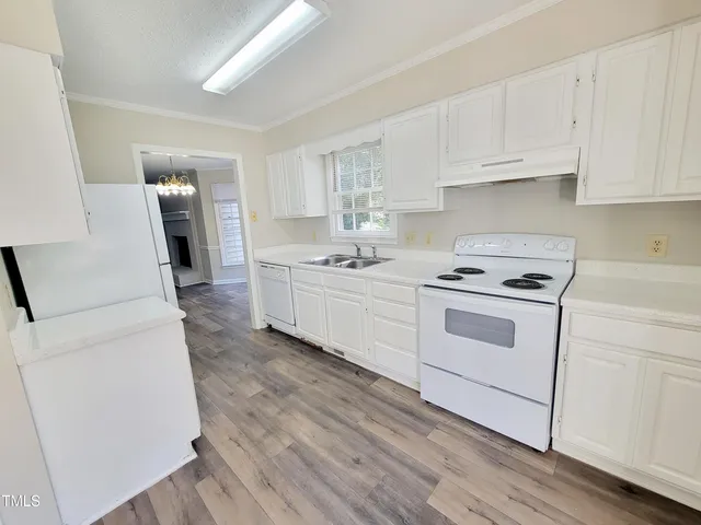 a kitchen with white cabinets and white appliances
