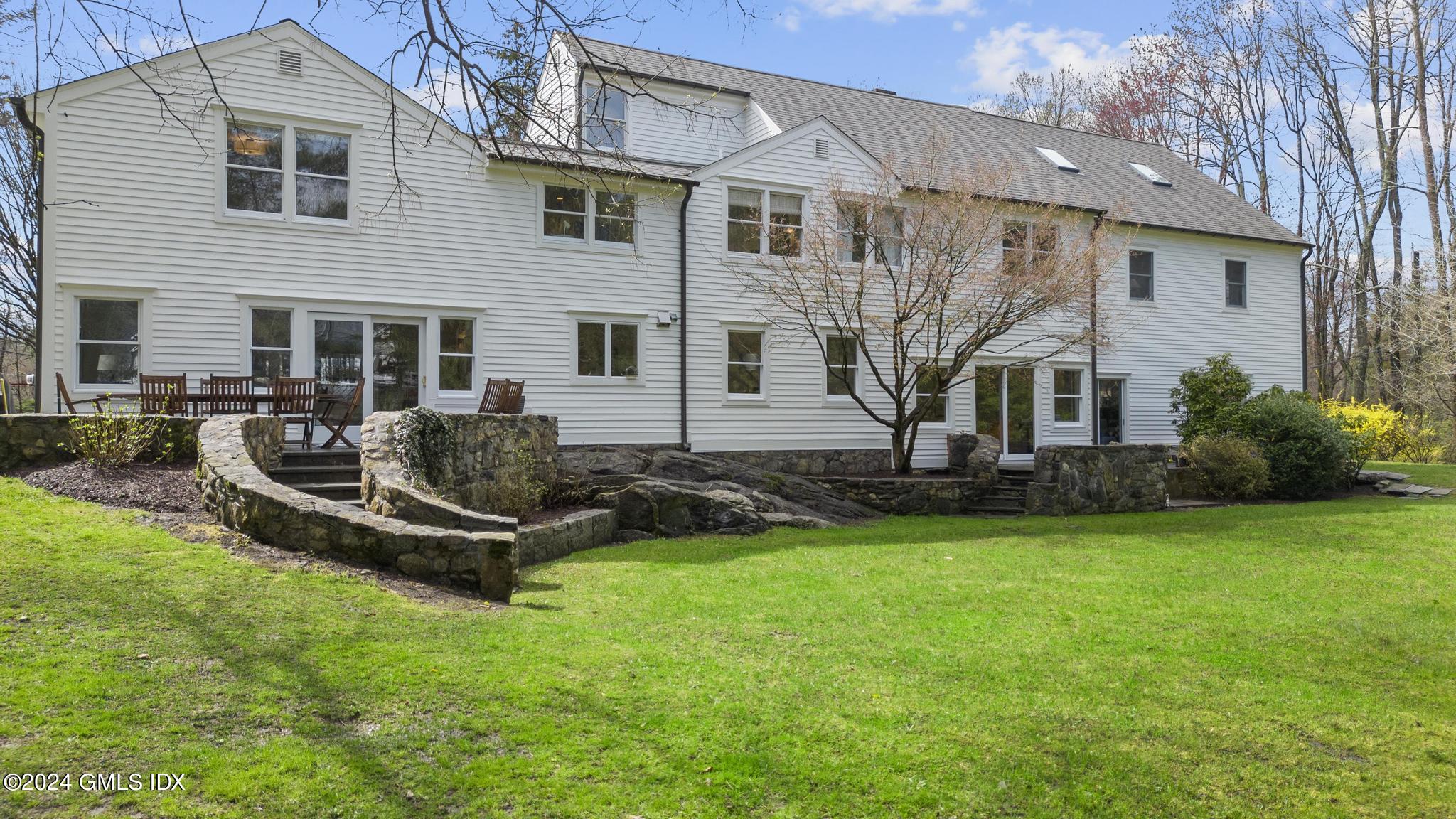 311 Cognewaugh Road Cos Cob, CT 06807 - Photo 19 of 28 a front view of a house with garden and trees