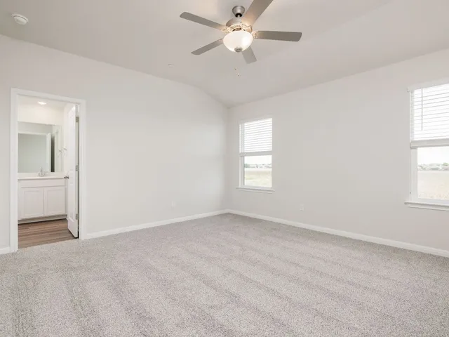 an empty room with a window and a ceiling fan