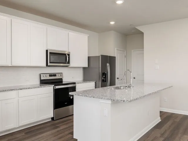 a kitchen with kitchen island a sink stainless steel appliances and cabinets