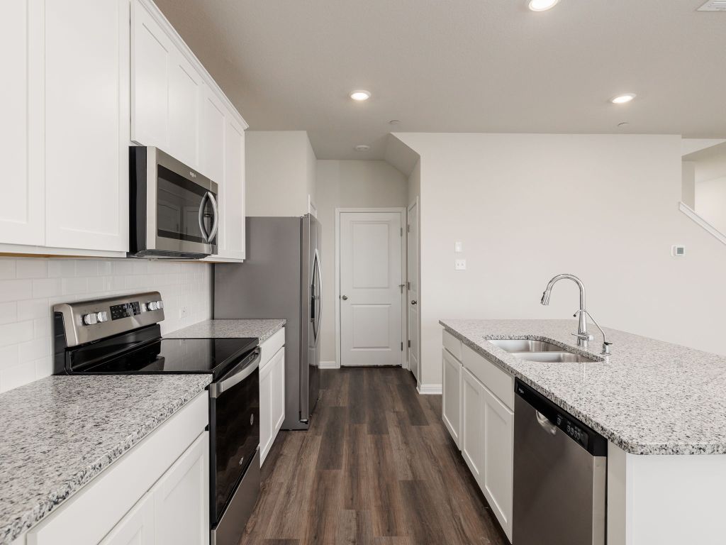 105 Texas Agate Drive, Unit 5 Kyle, TX 78640 - Photo 6 of 19 a kitchen with a sink stove top oven and refrigerator