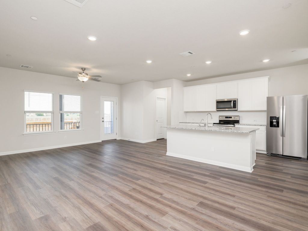 105 Texas Agate Drive, Unit 5 Kyle, TX 78640 - Photo 19 of 19 a view of kitchen with granite countertop wooden floor stainless steel appliances and a window