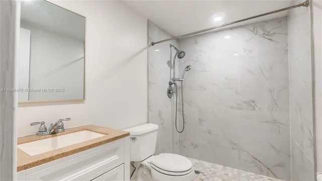 a bathroom with a shower toilet and sink