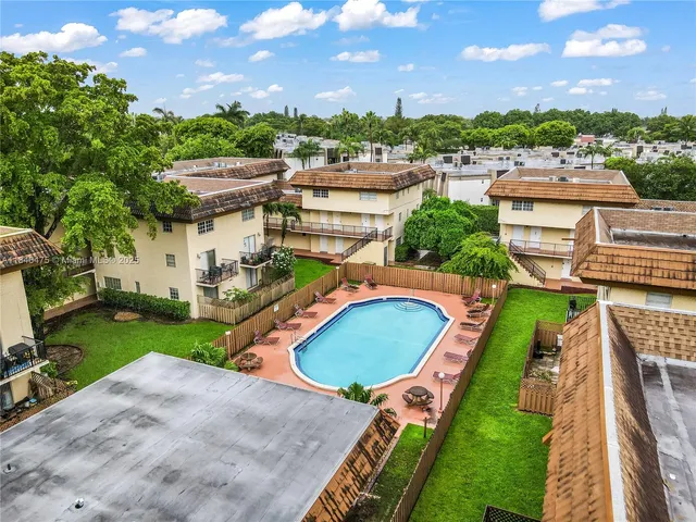a aerial view of a house with swimming pool and lawn chairs