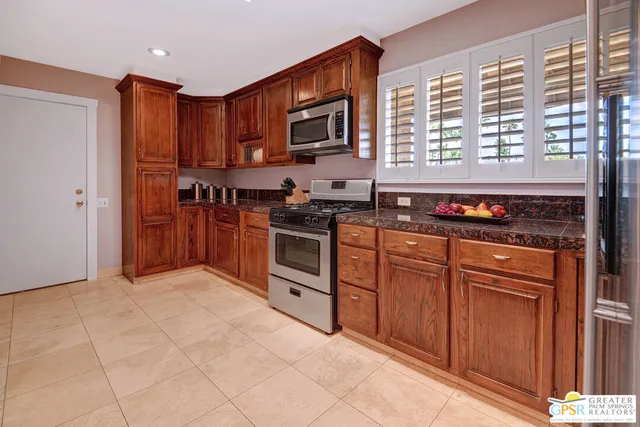 a kitchen with stainless steel appliances granite countertop a stove a sink and a refrigerator