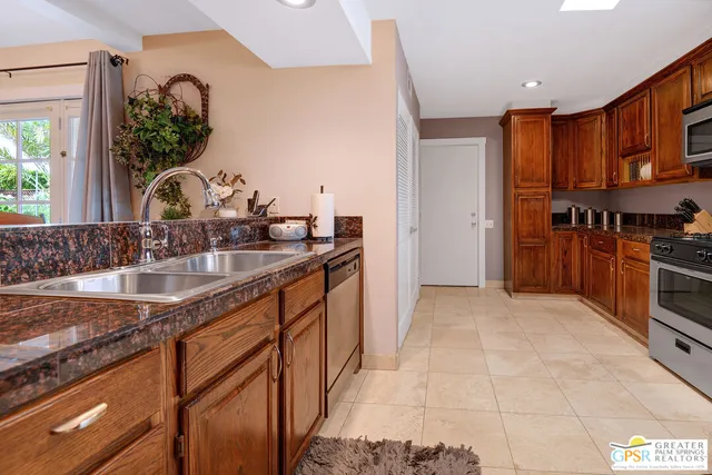 a kitchen with stainless steel appliances granite countertop a sink stove and cabinets