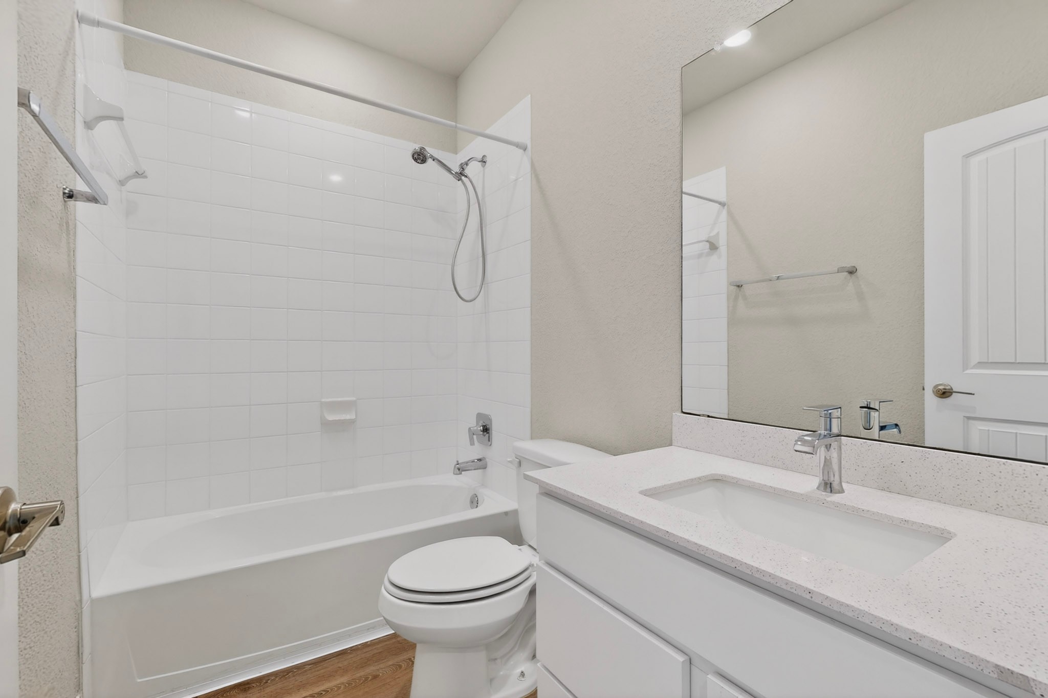 16809 Guido Cove Pflugerville, TX 78660 - Photo 24 of 40 Bathroom featuring a white bathtub with subway tile surround, a built-in toilet, a vanity with a light-colored countertop, and a large wall-mounted mirror